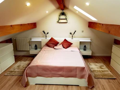 a bedroom with a large bed with red pillows at Chaleureuse Maisonnette Lyon in Meyzieu