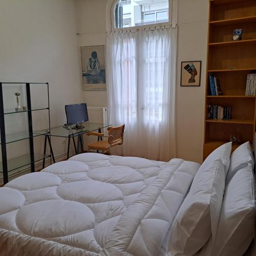 a large white bed in a room with a window at Maria's apartments in Thessaloniki