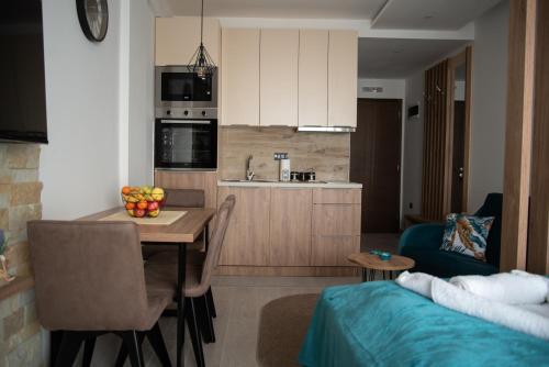a kitchen and living room with a table and a couch at Apartman Larisa in Kopaonik