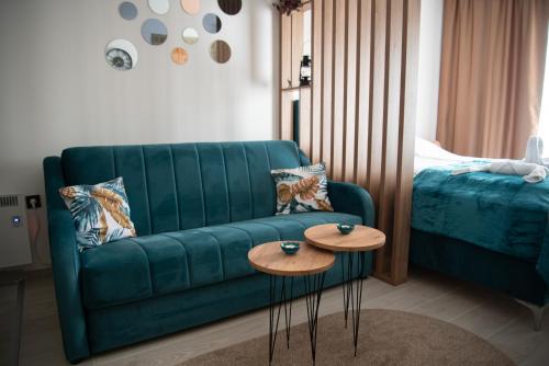 a living room with a green couch and two tables at Apartman Larisa in Kopaonik