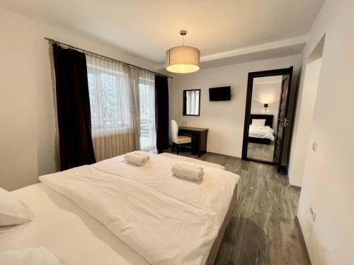 a white bed in a room with a mirror at Pensiunea Mirage in Iaşi
