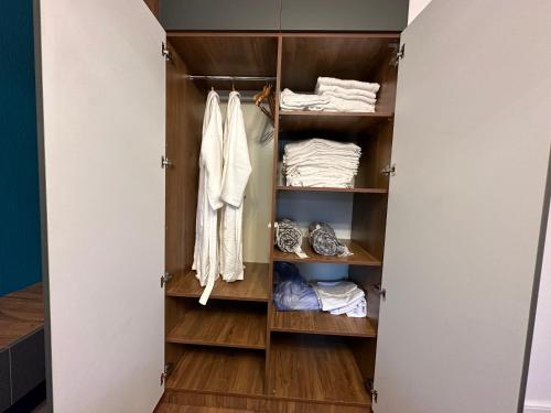 a walk in closet with wooden shelves and towels at Golden Old Avlabari in Tbilisi City