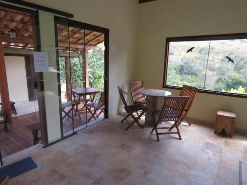 a room with chairs and a table and a window at Chalés de Minas Hotel Fazenda in Caxambu
