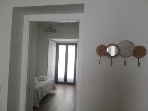 a room with a bed and two mirrors on the wall at CASA PALACIO CABALLEROS 7 con Parking in Sanlúcar de Barrameda