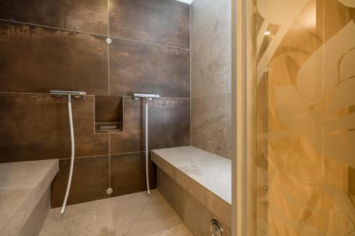 uma casa de banho com um chuveiro e uma porta de vidro em Schlosshotel Rosenau Superior em Schloss Rosenau