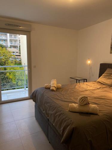 een slaapkamer met een groot bed en handdoeken bij Monaco Grand Prix Nouveau in Beausoleil
