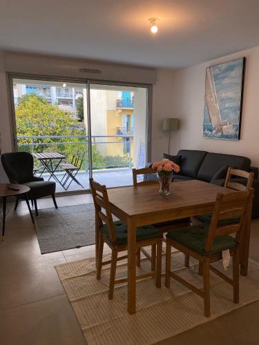 een woonkamer met een houten tafel en stoelen bij Monaco Grand Prix Nouveau in Beausoleil