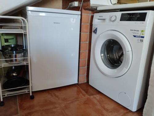 a white washing machine sitting next to a brick wall at Casa Harillo-Charming 1 bedroom in Genal mountains in Genalguacil