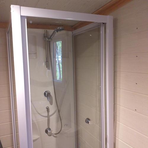 a shower with a glass door in a bathroom at Tiny & spa La Libellule en Périgord in La Force