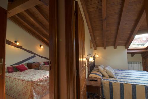 Casa Pinna في سانتيانا ديل مار: غرفة نوم بسريرين في غرفة ذات سقف خشبي
