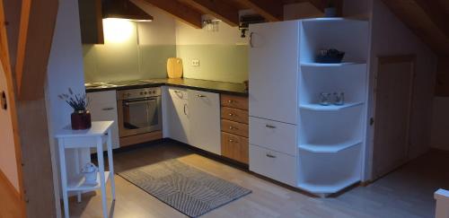 uma cozinha com armários brancos e um frigorífico branco em Apartment Hohenwerfen em Werfen