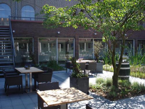 a patio with tables and chairs in front of a building at Leerhotel Het Klooster in Amersfoort