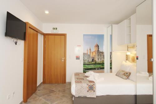 una camera d'albergo con letto e TV di Casa Boytac by CosyCasa Praia Peniche a Peniche