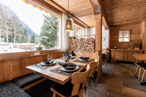 a dining room with a table and a large window at Typically Swiss Hotel Ermitage in Kandersteg