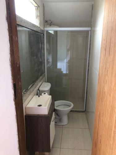 a bathroom with a toilet and a sink and a shower at Pousada Litorânea in Saquarema