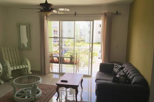 a living room with a couch and a table and a window at Nice Apt in punta cana 7 minutes from airport , 10 minutes from the beaches in Punta Cana