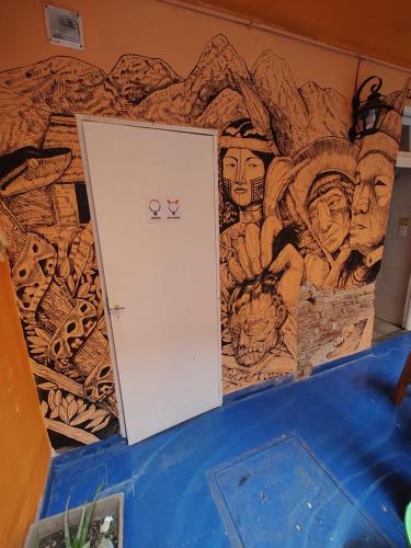 a room with a wall covered in paintings at CASA ARTIGAS Hostel in Cordoba