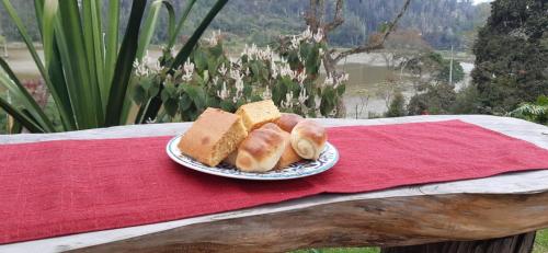 a plate of bread on a table with a red cloth at Glamping Laguna Sagrada in Bobadilla