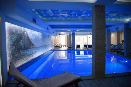 a hotel swimming pool with a painting on the wall at Apartmani Leki in Kopaonik