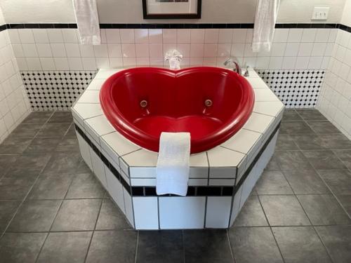 La salle de bains est pourvue d'une baignoire rouge au milieu. dans l'établissement Whalers Inn and Suites, à New Bedford