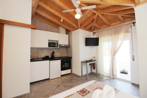 a kitchen with white cabinets and a ceiling fan at Casa Boytac by CosyCasa Praia Peniche in Peniche