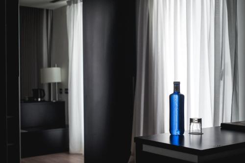 a blue bottle sitting on a table in front of a window at Axor Feria in Madrid
