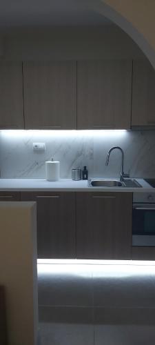 uma cozinha branca com um lavatório e uma luz em Filip Luxury Suite em Belgrado
