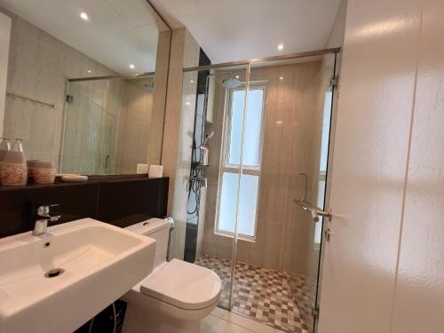a bathroom with a toilet and a sink and a shower at The Shore Melaka in Melaka