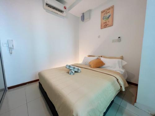 a small bedroom with a bed with a teddy bear on it at The Shore Melaka in Melaka