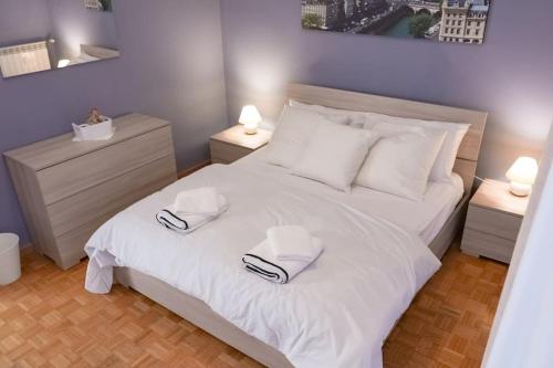 a bedroom with a white bed with two towels on it at [Elegant Apartment] in Bergamo Center in Bergamo