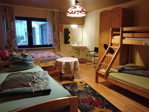 Zimmer mit 3 Etagenbetten und einem Waschbecken in der Unterkunft Ruhiges Keller Apartement NM in Neumarkt in der Oberpfalz