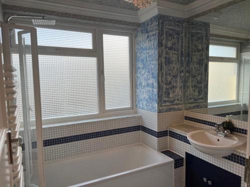 a bathroom with a tub and a sink at TJ Homes - One double bed room with garden view - Next to tube station in Ruislip