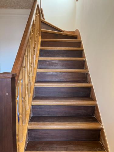 a staircase with wooden treads in a house at TJ Homes - One double bed room with garden view - Next to tube station in Ruislip