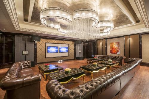 a large room with leather furniture and a chandelier at InterContinental Heilong Lake, an IHG Hotel in Meishan