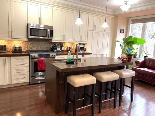 a kitchen with a large island with bar stools at Luxury Home - Upper Toronto Beaches in Toronto