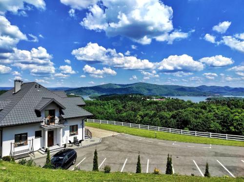 a house on a hill with a view of a lake at Noclegi Rezydent Polańczyk in Polańczyk