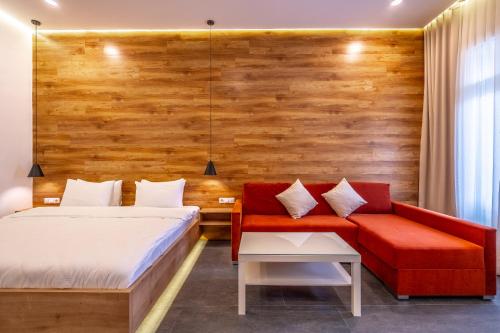 a bedroom with a bed and a red couch at 5 STAR APART HOTEL in Tbilisi City