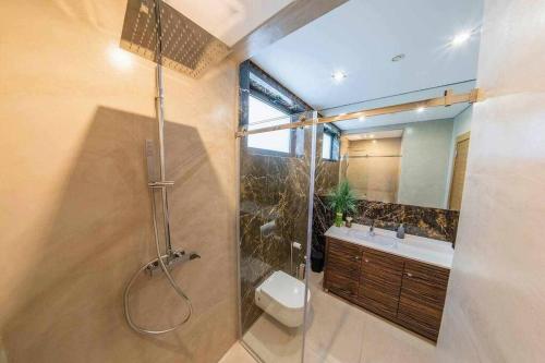 uma casa de banho com um chuveiro, um WC e um lavatório. em Luxurious VILLA 6 BD W/heated pool , GOLF, Beach em Almancil