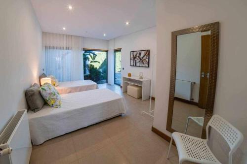 um quarto com 2 camas e um espelho em Luxurious VILLA 6 BD W/heated pool , GOLF, Beach em Almancil