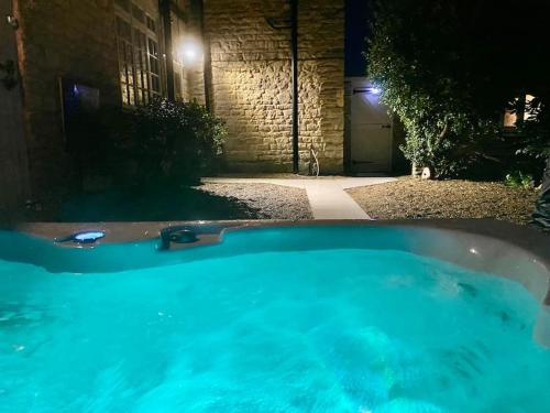 a hot tub in front of a building at night at The Retreat-luxury cottage with hot tub (sleeps 4) 