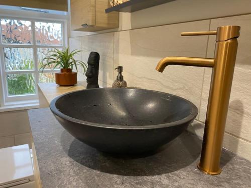 a black bowl sink in a bathroom with a faucet at The Retreat-luxury cottage with hot tub (sleeps 4) 