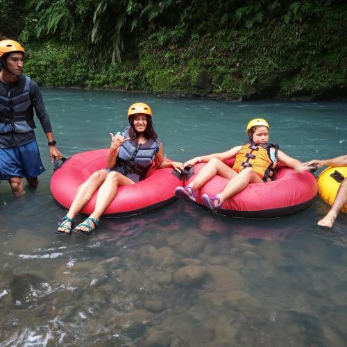 a group of people sitting in rafts in a river at Hospedaje Rio Celeste Katira, Habitación privada in San Rafael