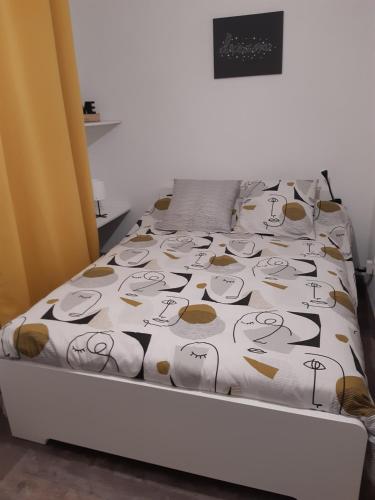 a bed with a hello kitty comforter on it at Joli appartement T2 Agglo Troyes in Sainte-Savine