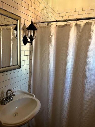 a bathroom with a shower curtain and a sink at Hotel Villas Ajijic, Ajijic Chapala Jalisco in Ajijic