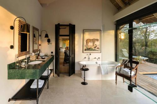 a bathroom with two sinks and a large window at Monwana in Thornybush Game Reserve