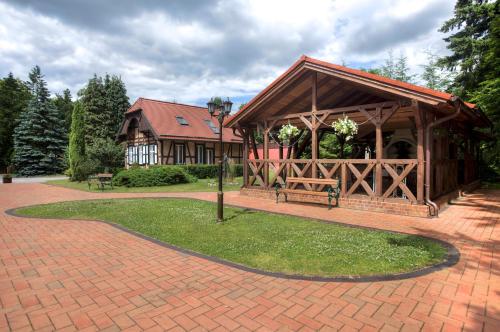 a building with a pavilion on a brick walkway at Jagdschloss Waldsee in Waldsee