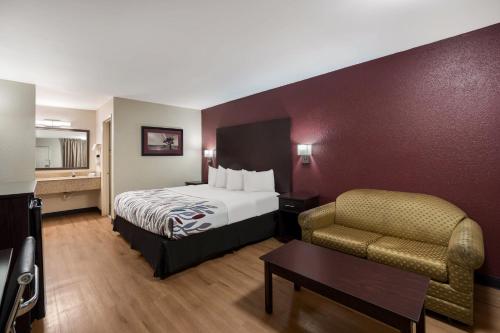 a hotel room with a bed and a chair at Red Roof Inn Bishopville in Bishopville