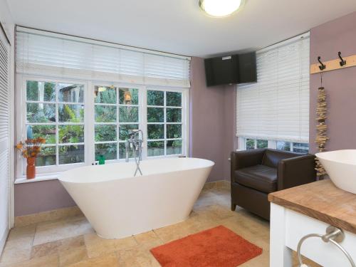 a bath tub in a bathroom with windows at St Ives View in St Ives