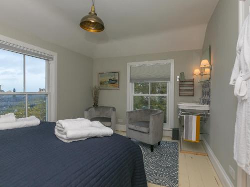 a bedroom with a bed and a chair and a window at St Ives View in St Ives