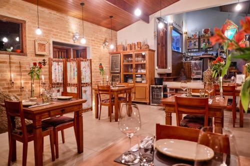 ein Esszimmer mit Holztischen und Stühlen in der Unterkunft Pousada Teto do Cafundó in São Francisco Xavier